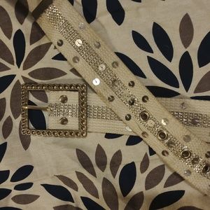 White canvas belt. Isit is embellished with silver design andseqinns